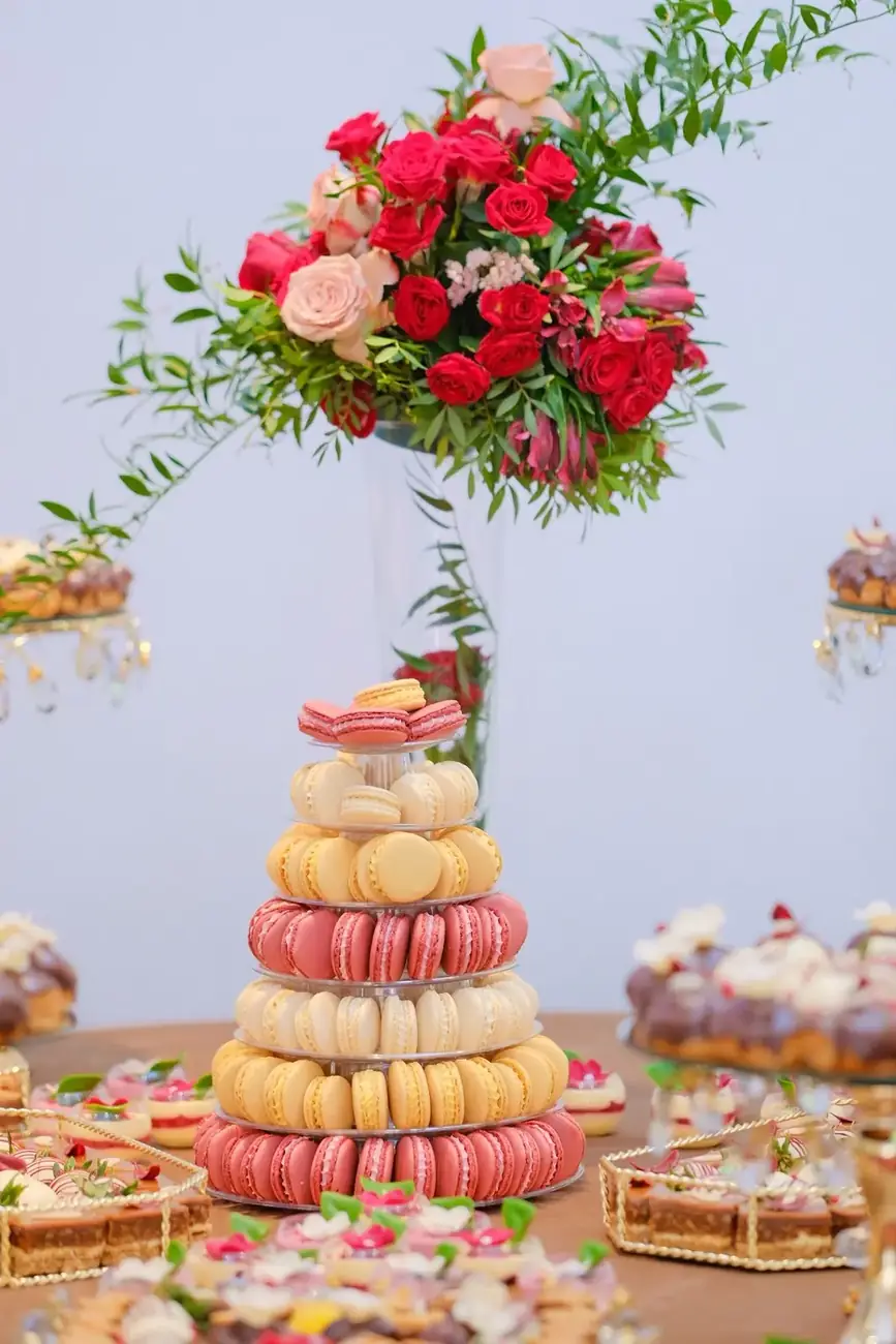 Turn de macarons sub un aranjament de trandafiri