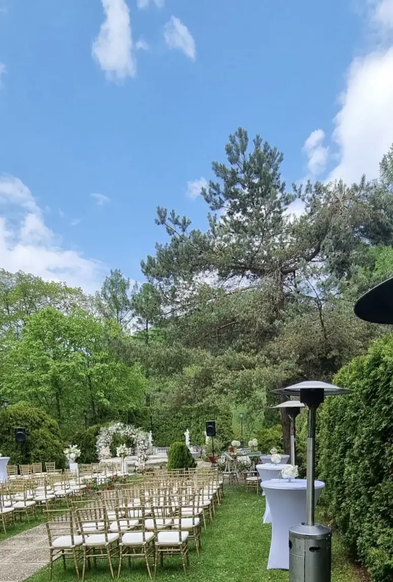 Ceremonia în grădină, cu scaune aurii și flori albe